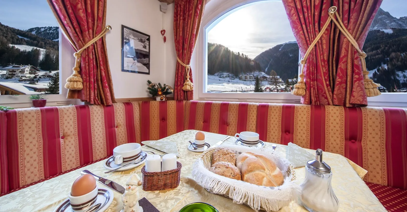 Frühstückstisch in der Stube mit Blick auf die verschneiten Berge