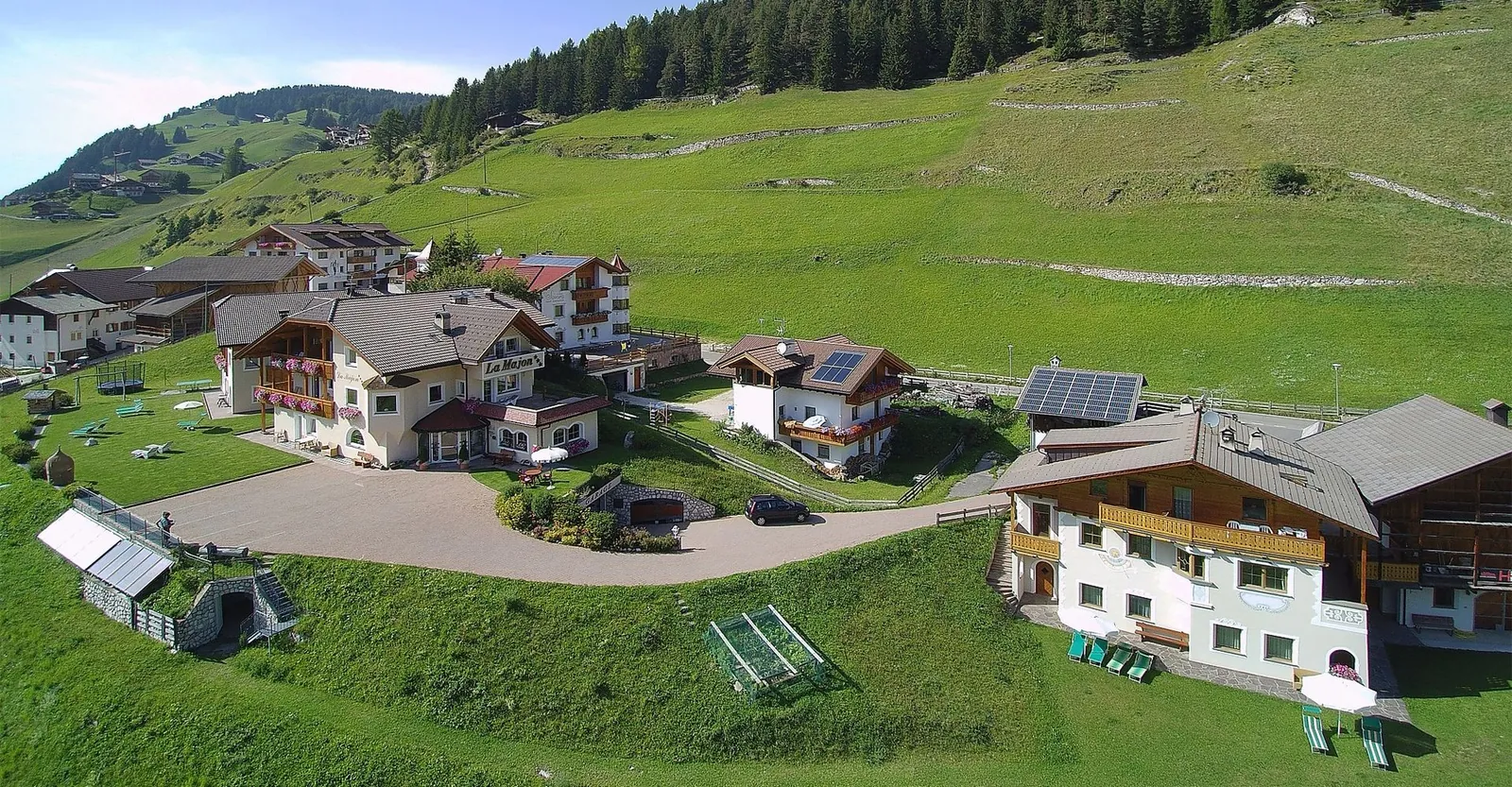 Luftbild von La Majon und der Dependance am Hang in Wolkenstein